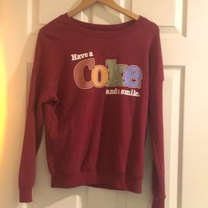 “have a coke and smile.” sweater, maroonish color